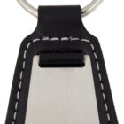 A keychain with a metal plate and a black leather base. The leather has white stitching along the edges. The metal ring is attached at the top of the leather section.