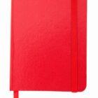 A closed red notebook with a textured cover, featuring an elastic band on the right side and a ribbon bookmark emerging from the bottom edge. The notebook has rounded corners.