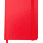 A closed red notebook with rounded corners and a red elastic band wrapped vertically around the right side. A matching red ribbon bookmark extends from the bottom. The cover has a slightly glossy texture.