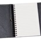 A black leather-bound spiral notebook is open, revealing blank lined pages inside. The notebook is centered against a plain white background.