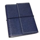 A closed dark blue textured leather journal secured with a black elastic strap. It features white stitching along the edges.