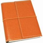 An orange leather-bound journal with a textured cover, secured by an orange elastic band wrapped around it. The journal has white stitching along the edges.