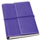 Purple leather-bound journal with a wraparound closure, featuring white stitching on the edges. The journal is slightly open, revealing a glimpse of the pages inside.