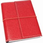 A red leather textured notebook is closed and secured with a thin, elastic band wrapped around it vertically and horizontally.
