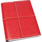 A red leather-bound notebook with white stitching, secured by a thin, light brown elastic band wrapped around it. The texture of the leather is slightly textured, giving it a rugged appearance.