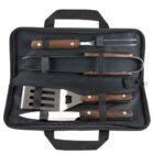 A black carrying case with handles open to reveal barbecue utensils. Inside are a spatula, fork, tongs, and knife, each with wooden handles and secured by black straps.