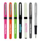 Seven colorful pens with various brand names, standing upright.