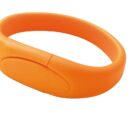 An orange silicone wristband with a smooth, oval-shaped central area, likely for a logo or text. The band is shown on a white background, highlighting its vibrant color and flexible material.