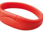 A red silicone wristband with a flat, oval section on one side, designed for comfort and flexibility.
