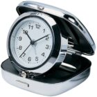 A shiny silver travel alarm clock with a white face and black numbers, housed in a partially open, compact case. The clock shows the time as 10:10, and the case has a smooth, reflective surface.