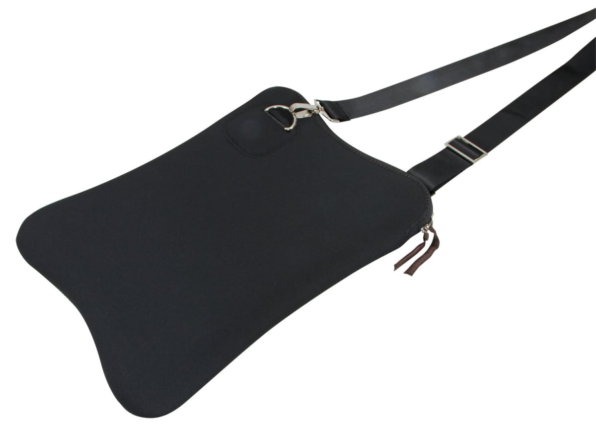 A black shoulder bag with a unique trapeze shape, featuring a silver ring attachment and an adjustable strap. The bag has a zippered opening with dual zipper pulls and a small circular design near the top.