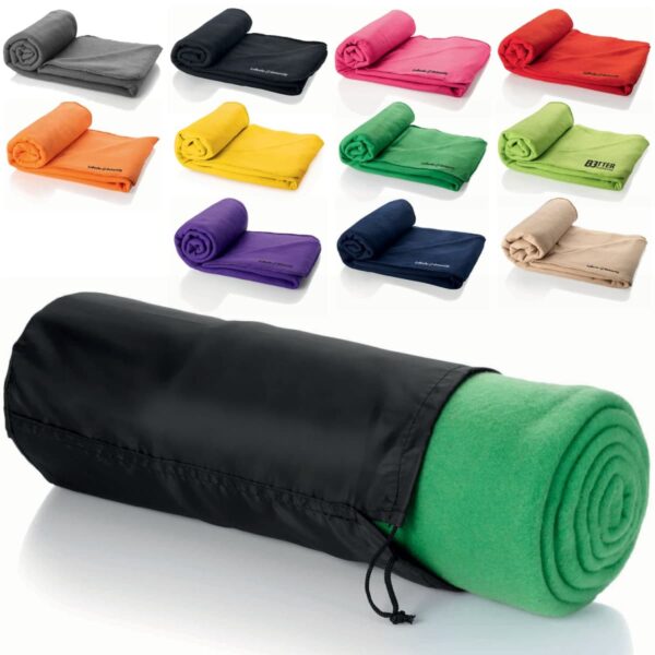 A rolled-up green blanket in a black carrying case is in the foreground. Behind it are twelve other rolled-up blankets in various colors, including black, pink, orange, yellow, purple, red, green, blue, beige, and tan.