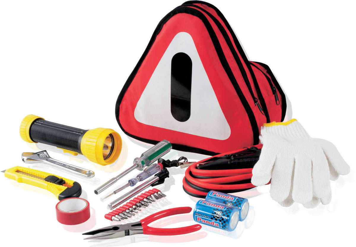 A roadside emergency kit including a triangular red and white bag, flashlight, gloves, jumper cables, screwdriver set, wrench, pliers, utility knife, electrical tape, batteries, and a small tool kit, arranged on a white background.