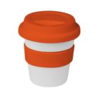 A white reusable coffee cup with an orange silicone lid and an orange grip band around the middle. The cup is designed to resemble a classic to-go coffee cup.
