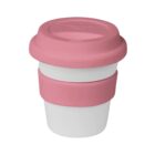 A reusable coffee cup with a white body and pink silicone lid and grip band, set against a plain white background.
