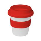 A reusable coffee cup with a white base and two red silicone bands, one acting as a lid and the other as a grip in the middle. The cup is isolated on a plain white background.
