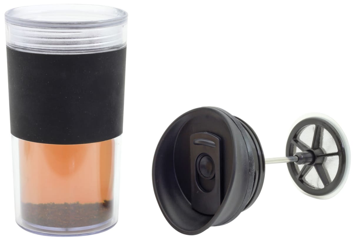 A transparent travel mug with a black grip and a removable lid is shown. Next to it is a black plunger with a mesh filter, designed for making coffee or tea on the go. The mug contains a brown liquid and some coffee grounds at the bottom.