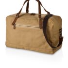 A tan canvas duffel bag with brown leather handles and trim, featuring a zipper pocket on the side and a dark brown adjustable shoulder strap. The bag is positioned on a white background.