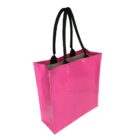 A glossy pink tote bag with black handles is shown at an angle, displaying its rigid structure and smooth finish. The interior appears light-colored, contrasting with the vibrant pink exterior.
