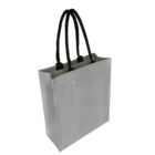 A gray tote bag with black handles is shown against a white background. The bag appears glossy, with a simple and modern design.