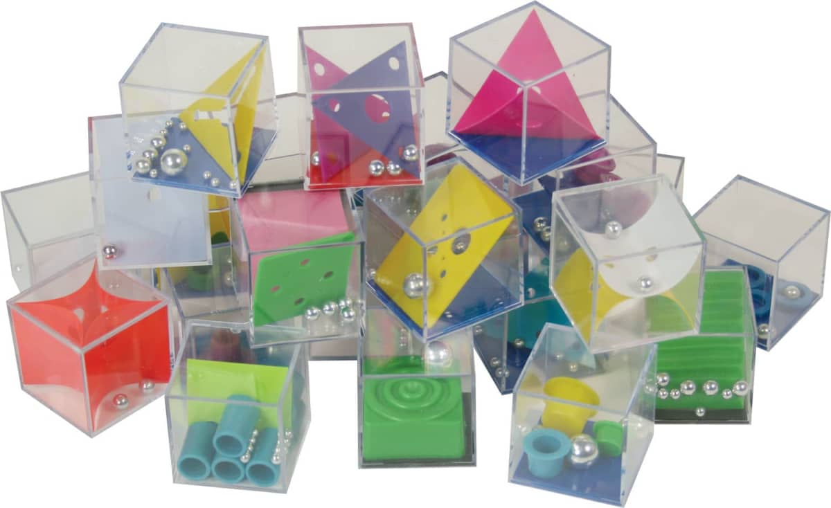 A collection of transparent puzzle cubes filled with colorful geometric shapes, beads, and small tubes. The cubes are stacked haphazardly, showcasing various colors like red, blue, yellow, and green.