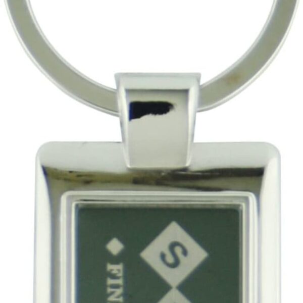 A rectangular silver keychain with a dark green center features three diamond shapes in a vertical line. The letters S, Y, and T are in white, each inside a diamond. The word FINANCES is vertically aligned on the left.