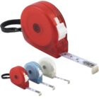 Four retractable tape measures in red, blue, white, and translucent white. Each measure shows numbers and markings. The red one is larger and in the foreground, with a black strap attached.