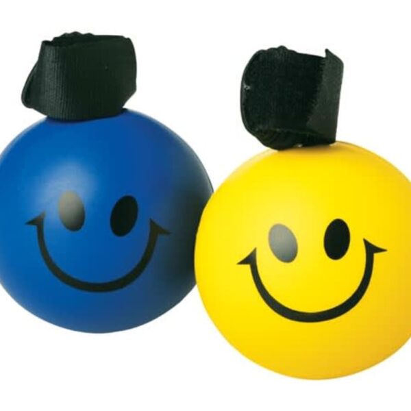 Two round stress balls with smiley faces, one blue and one yellow, each with a black strap on top. They are placed side by side against a plain white background.