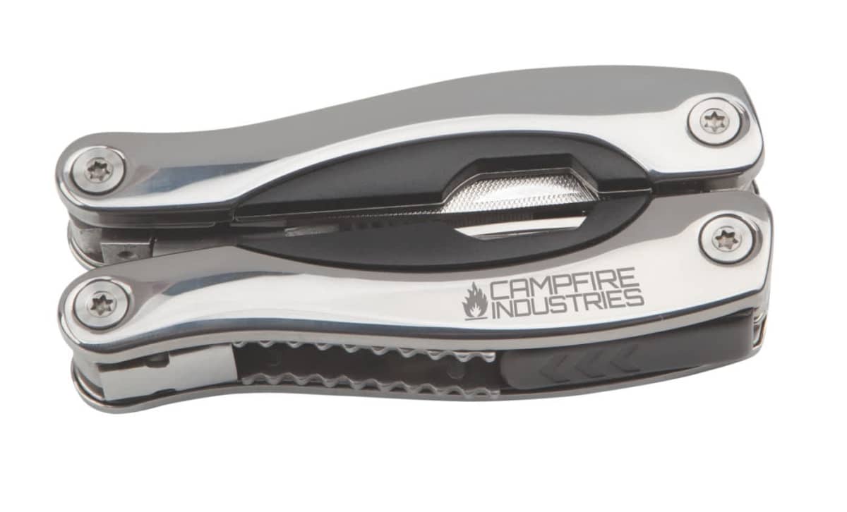 A compact multi-tool with stainless steel components, marked with the logo Campfire Industries. The tool is folded, displaying a sleek design with visible screws and a textured grip section.