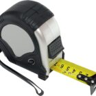 A black and silver retractable measuring tape with a yellow extended tape showing markings from 0 to 7 inches. The tape has a loop handle on one side and a metal hook on the end of the tape.