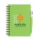 A green spiral-bound notebook with the logo AWLIN Technical School on the cover. The design includes orange and green dots arranged in a pattern. A matching green pen is clipped to the side.