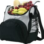A black and gray cooler bag is open, displaying its contents: a loaf of bread, a bunch of red grapes, and several bananas. The bag features a front pocket and an adjustable shoulder strap.