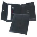 A black portfolio organizer with a flap opened to reveal a notepad labeled orso, two pens in pen holders, and a pocket holding a document. A silver pen is clipped on the flap. The organizer is partially closed.