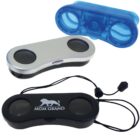 Three compact binoculars are shown: one with a silver finish, another in black with MGM Grand and a lion logo, and a third in translucent blue. The black binoculars include a neck strap with an adjustable toggle.