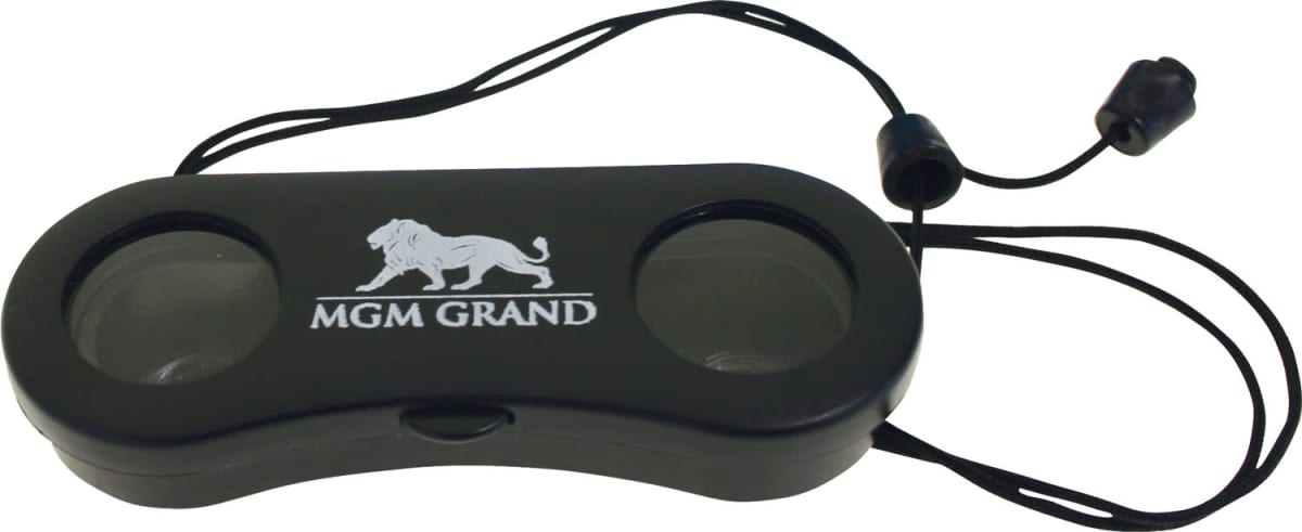 A black pair of binoculars with a neck strap. The binoculars have the MGM Grand logo featuring a lion graphic on the bridge between the lenses.