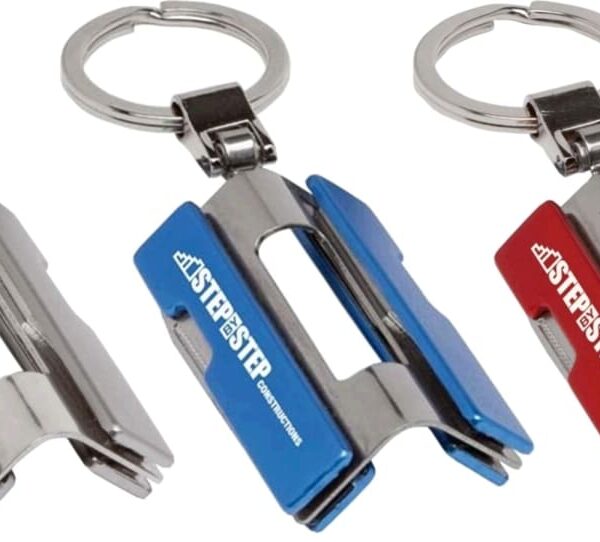 Three keychains, each featuring metal belt-clip attachments in silver, blue, and red colors. The clips have the text STP.STP printed on them and are attached to silver key rings.