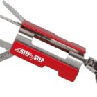 A red multi-tool keychain with various tools extended, including a ruler, three flat implements, and an attachment ring. The tool has STEP BY STEP printed in white on its side.