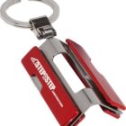 A keychain in the shape of a red and silver staple remover, with STEP STEP CONSTRUCTIONS printed on it.