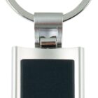 A silver keychain with a rectangular black center is shown. The keychain features a circular metal loop at the top for attaching keys.