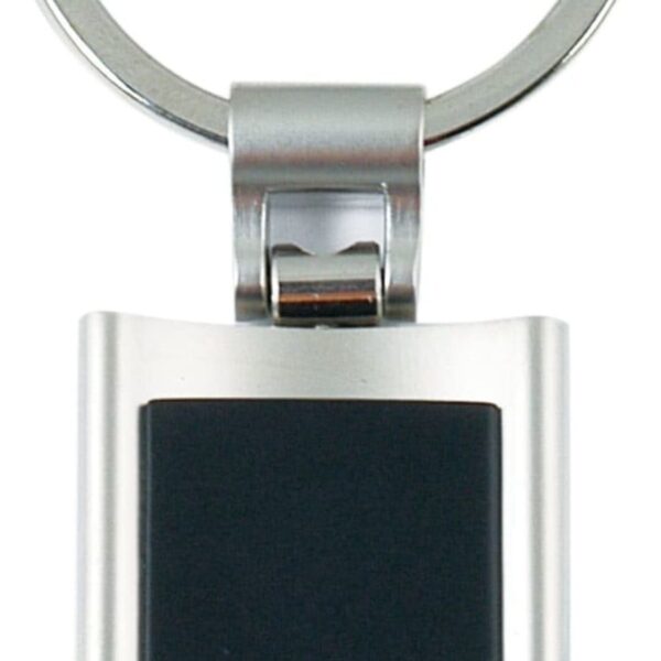 A metallic keychain featuring a rectangular black inlay. The keyring is attached to the top of the metallic frame, which has a shiny, smooth finish.