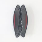 A black folding pocket knife is closed, showing its handles with red accents. The blade and inner components are not visible. The knife is positioned vertically on a plain white background.