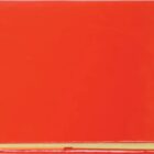 A closed book with a bright red cover and visible yellowed pages at the bottom, set against a white background.