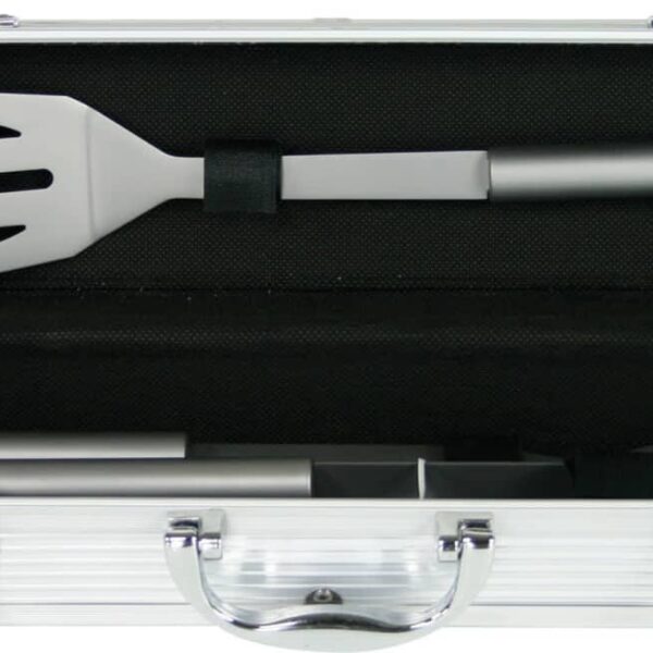 Open silver case containing stainless steel barbecue tools, including a spatula and tongs, secured inside with straps. The case has a handle and latch closures.