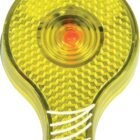 A close-up of a yellow and orange plastic light reflector with a textured, honeycomb pattern. The reflector has a rounded top and a flat base with white lines.