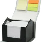 Black desktop organizer with a variety of sticky notes. The lid holds yellow, orange, and green sticky notes, while the base contains a stack of white note paper. The organizer is open, showing its contents.