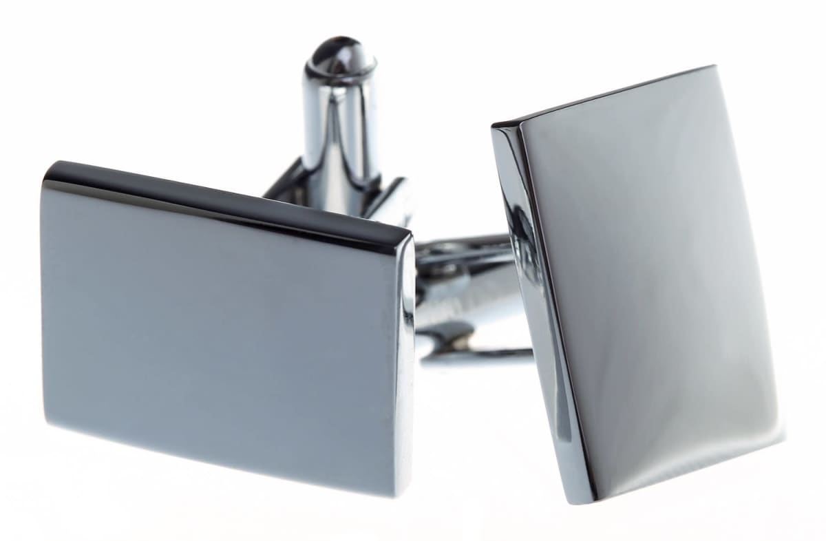 Two sleek, rectangular silver cufflinks with a shiny finish are displayed against a white background. They have a minimalist design, featuring smooth surfaces and clean edges, reflecting light elegantly.