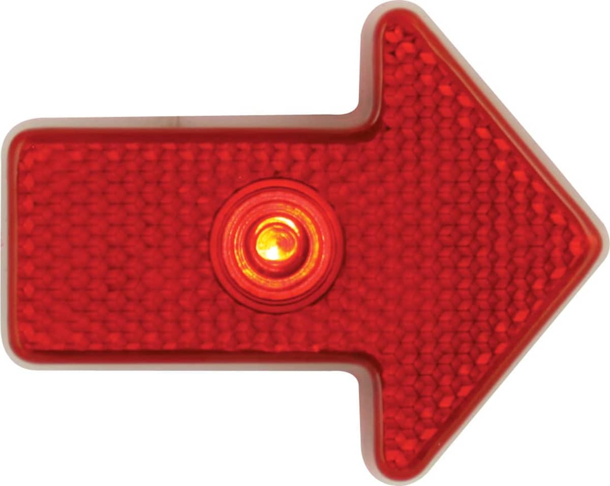 A red arrow-shaped light with a textured surface and a circular central light, pointing to the right.
