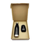 Open cardboard box displaying a black and gold insulated bottle and a matching small black container. Both items feature a white logo. The box lid is partially visible.