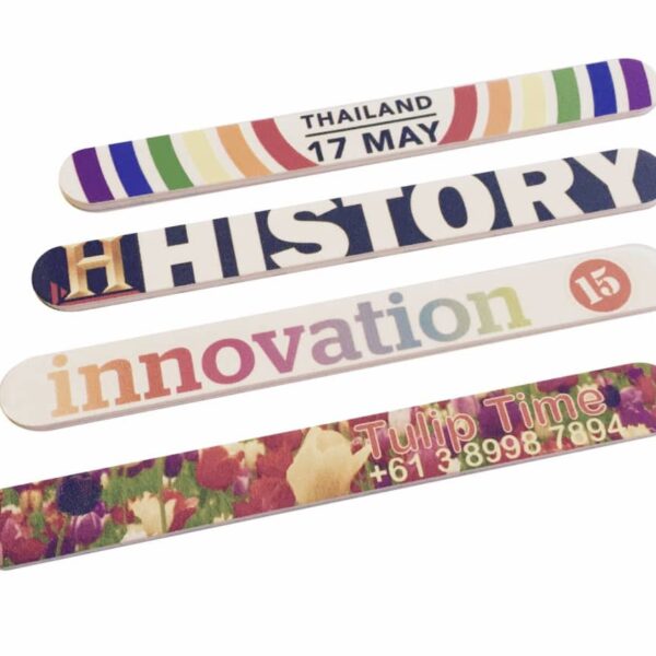 Four colorful popsicle sticks are laid out. They are labeled THAILAND 17 MAY, HISTORY, innovation 15, and Tulip Time +61 3 8998 7894, each with unique designs and vibrant colors.