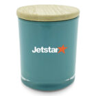A teal ceramic jar with a light wooden lid, featuring the Jetstar logo in white and orange on the front.